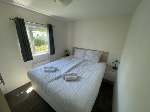 Camera luminosa al Berkel 6 lodge presso Zuiderzee, Paesi Bassi, con letto matrimoniale e finestra ampia.
