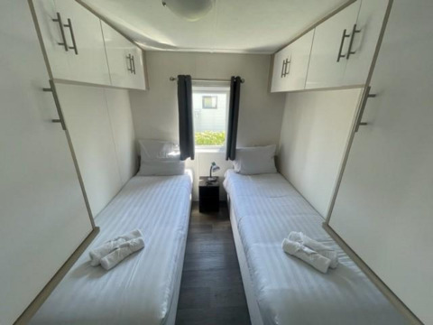 Bright twin bedroom at Berkel 6 lodge in Zuiderzee, Netherlands, featuring clean, modern white decor.