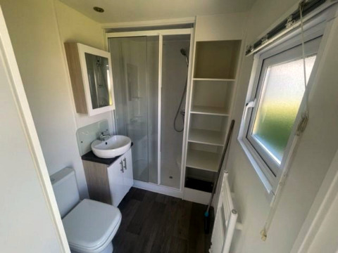Moderne badkamer met douche, wastafel, toilet, raam en kast in Berkel 6 lodge bij Zuiderzee, Nederland.