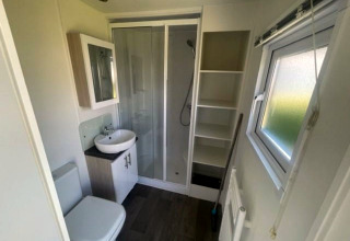 Moderne badkamer met douche, wastafel, toilet, raam en kast in Berkel 6 lodge bij Zuiderzee, Nederland.