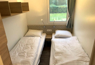 Twee eenpersoonsbedden in een knusse kamer van de Cosy Unique 2+4 lodge bij Zuiderzee, Nederland.