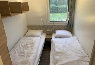 Dos camas individuales en una habitación acogedora de la lodge Cosy Unique 2+4 en Zuiderzee, Países Bajos.