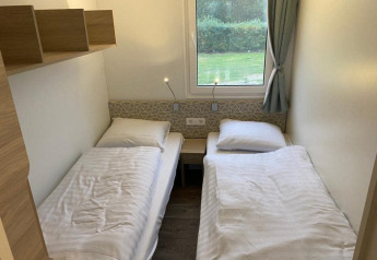 Twee eenpersoonsbedden in een gezellige kamer van de Cosy Unique 2+4 lodge aan Zuiderzee, Nederland.
