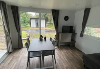 Moderne lodge met eethoek en zicht op tuin bij Cosy Unique 4 in Zuiderzee, Nederland.