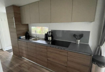Moderne Küchenzeile in der Cosy Unique 4-Lodge am Zuiderzee, Niederlande, mit Holzoptik und Fenster.