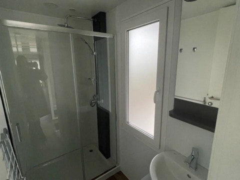Moderne badkamer met douche, wastafel en matglas raam in Cosy Unique 4, Zuiderzee, Nederland.