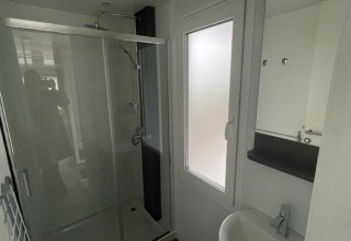 Modern bathroom with shower, sink, and frosted window at Cosy Unique 4, Zuiderzee, Netherlands.