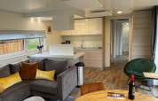 Moderne stue og køkken i Cottage 4 ved Zuiderzee, Nederlandene med hyggeligt interiør og træmøbler.