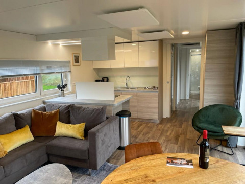 Moderne stue og køkken i Cottage 4 ved Zuiderzee, Nederlandene med hyggeligt interiør og træmøbler.