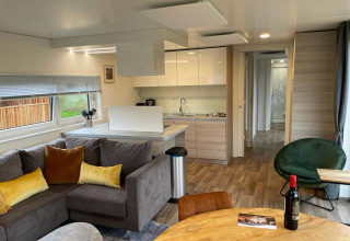 Moderne stue og køkken i Cottage 4 ved Zuiderzee, Nederlandene med hyggeligt interiør og træmøbler.