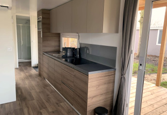 Cocina moderna en Cottage 4, Zuiderzee, Países Bajos, con acabados de madera y acceso a la terraza.