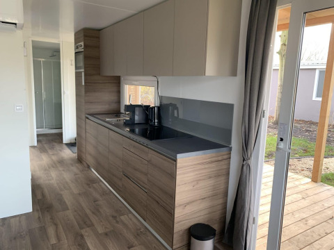 Moderne køkkeninteriør i Cottage 4, Zuiderzee, Holland, med træelementer og udgang til terrasse.