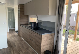 Moderne køkkeninteriør i Cottage 4, Zuiderzee, Holland, med træelementer og udgang til terrasse.