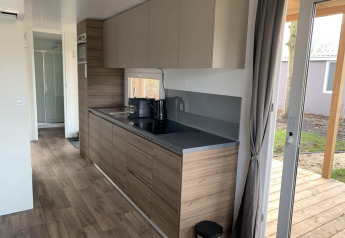 Moderne keukeninrichting in Cottage 4, Zuiderzee, Nederland, met houten afwerking en terrasdeur.