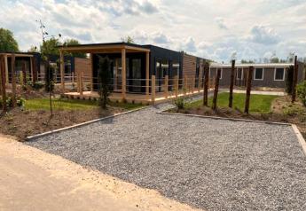 Cabaña moderna Cottage 4 en Zuiderzee, Países Bajos, con sendero de grava y terraza de madera soleada.