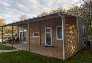 En moderne træhytte med overdækket terrasse i grønne omgivelser ved Cottage 4, Zuiderzee, Holland.