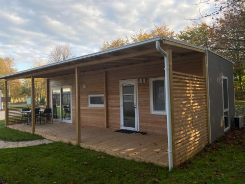 En moderne træhytte med overdækket terrasse i grønne omgivelser ved Cottage 4, Zuiderzee, Holland.