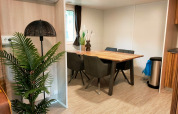 Salle à manger du Cottage 5 à Zuiderzee, Pays-Bas, avec table en bois, plantes et décoration moderne.