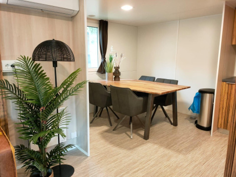 Comedor en Cottage 5 en Zuiderzee, Países Bajos, con mesa de madera, plantas y decoración moderna.