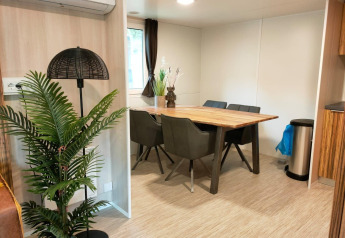 Eethoek in Cottage 5 te Zuiderzee, Nederland, met houten tafel, planten en moderne inrichting.