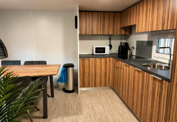 Moderne Küche und Essbereich in Cottage 5, Zuiderzee, Niederlande, mit Holzschränken und Geräten.