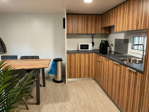 Cocina y comedor modernos en la cabaña 5 de Zuiderzee, Países Bajos, con armarios de madera y electrodomésticos.