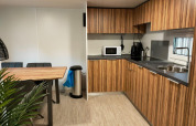 Cocina y comedor modernos en la cabaña 5 de Zuiderzee, Países Bajos, con armarios de madera y electrodomésticos.