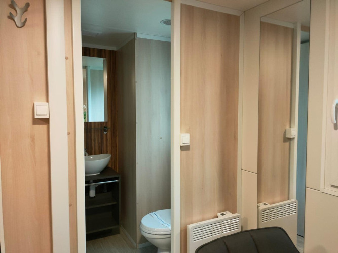 Moderne badkamer en wastafel in Cottage 5 bij Zuiderzee, Nederland, met houten wandafwerking.