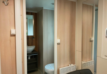 Modern interieur van badkamer in Cottage 5, Zuiderzee, Nederland, met houten panelen aan de wand.