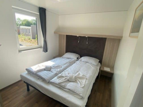Dormitorio luminoso con dos camas individuales y ventana en Cottage 5, Zuiderzee, Países Bajos, estilo moderno.
