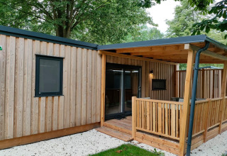 Udvendigt billede af Cottage 5 ved Zuiderzee i Holland, træbeklædt med overdækket terrasse.