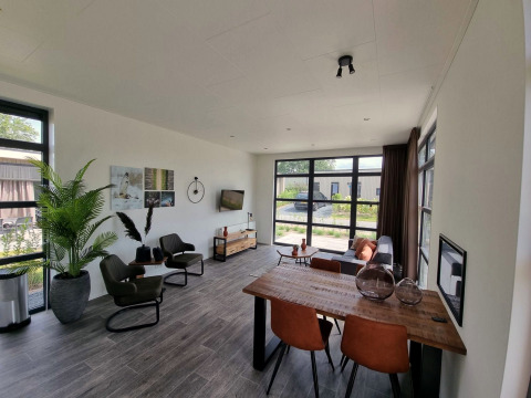 Salon moderne avec grandes fenêtres, coin repas et sièges confortables à Cube Maximaal 4, Zuiderzee, Pays-Bas.
