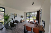 Modern living room with large windows, dining area, and cozy seating in Cube Maximaal 4, Zuiderzee, Netherlands.