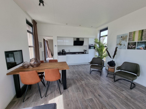Moderne indretning af Cube Maximaal 4 lodge ved Zuiderzee i Holland med stue, køkken og spiseplads.