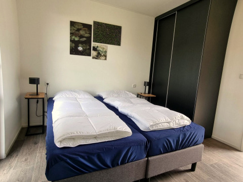 Chambre du Cube Maximaal 4 à Zuiderzee, Pays-Bas, avec deux lits simples et décoration moderne minimaliste.