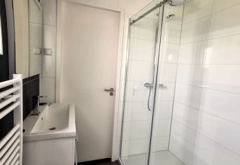 Baño moderno en Cube Maximaal 4 en Zuiderzee, Países Bajos, con ducha acristalada y lavabo elegante.