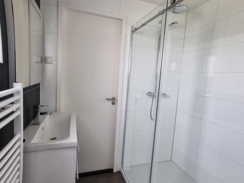 Modernes Badezimmer im Cube Maximaal 4 in Zuiderzee, Niederlande, mit Dusche und Waschbecken.