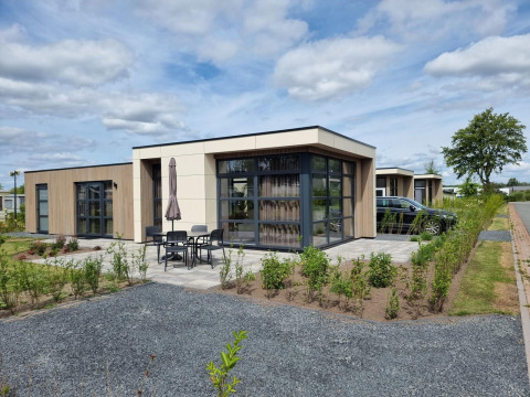 Cube Maximaal 4 lodge at Zuiderzee in the Netherlands features modern design and an outdoor patio area.