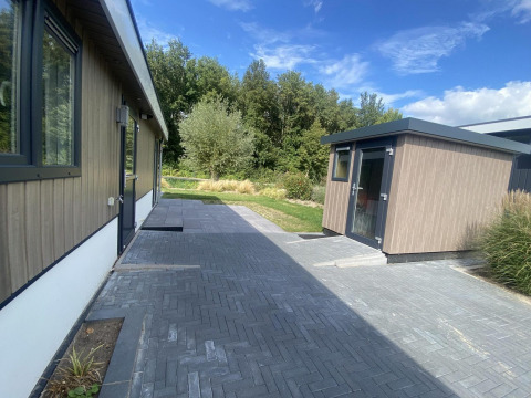 Buitenzicht op Hackfort MIVA-lodge aan Zuiderzee in Nederland, met terras en moderne uitstraling.