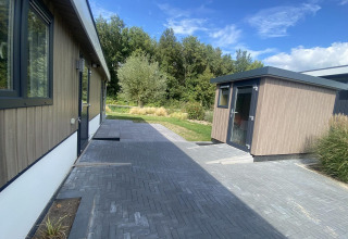 Vue extérieure du lodge Hackfort MIVA à Zuiderzee aux Pays-Bas, terrasse moderne et arbres environnants.
