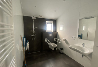 Rolstoeltoegankelijke badkamer in Hackfort MIVA-lodge bij Zuiderzee, Nederland, met douche en toilet.