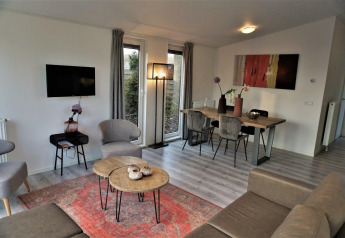 Gezellige woonkamer en eetruimte in Pavilion 4 bij Zuiderzee, Nederland, met modern interieur en warme uitstraling.