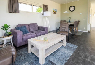Modern living room at Pavilion 4, Zuiderzee, Netherlands, with purple sofa, dining area and stylish decor.