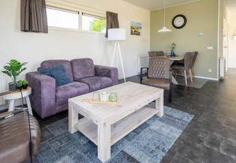 Moderne zithoek in Pavilion 4 te Zuiderzee, Nederland, met paarse sofa, eethoek en stijlvolle accenten.