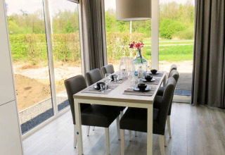 Salle à manger du Pavilion à Zuiderzee, Pays-Bas, avec une décoration moderne et vue sur le jardin.