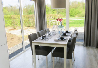 Eethoek in de Pavilion bij Zuiderzee, Nederland, met eigentijdse inrichting en uitzicht op de tuin.