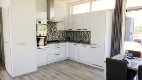 Cuisine moderne avec armoires blanches et carreaux mosaïques, Pavilion at Zuiderzee aux Pays-Bas, coin repas à côté.