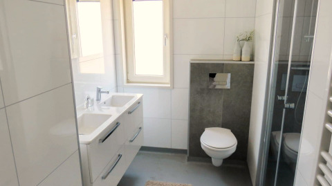 Salle de bains moderne au Pavilion at Zuiderzee aux Pays-Bas avec double vasque, toilettes murales et douche.