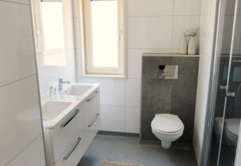 Salle de bains moderne au Pavilion at Zuiderzee aux Pays-Bas avec double vasque, toilettes murales et douche.