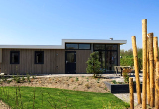 Pavillon moderne à Zuiderzee, Pays-Bas, doté d'un jardin, terrasse extérieure et façade en bois.